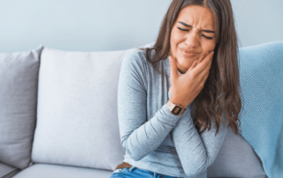 Image of woman holding her cheek in pain due to a cavity